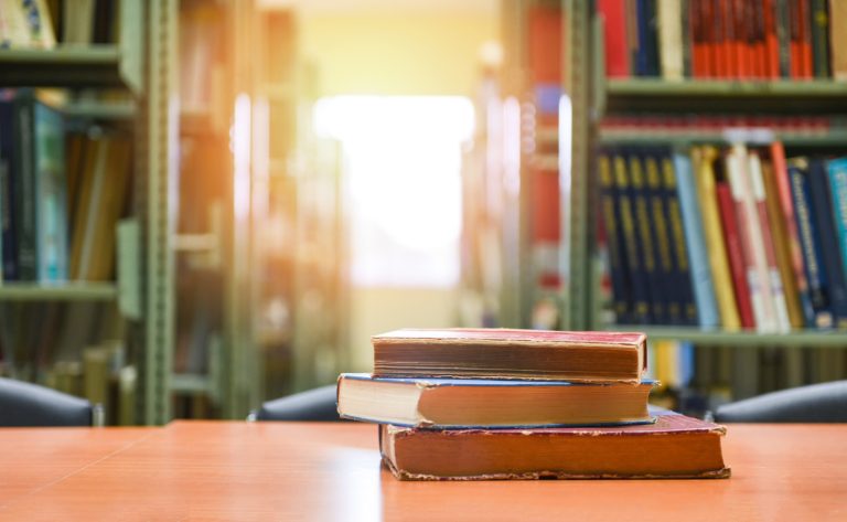 old books on a wooden table book stack in the library room for